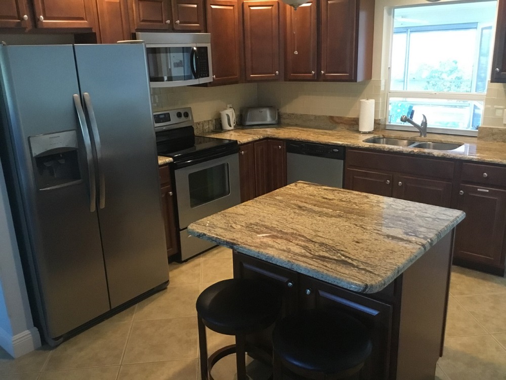A Fully Equipped Kitchen Featuring Granite Countertops And Stainless Steel Appliances